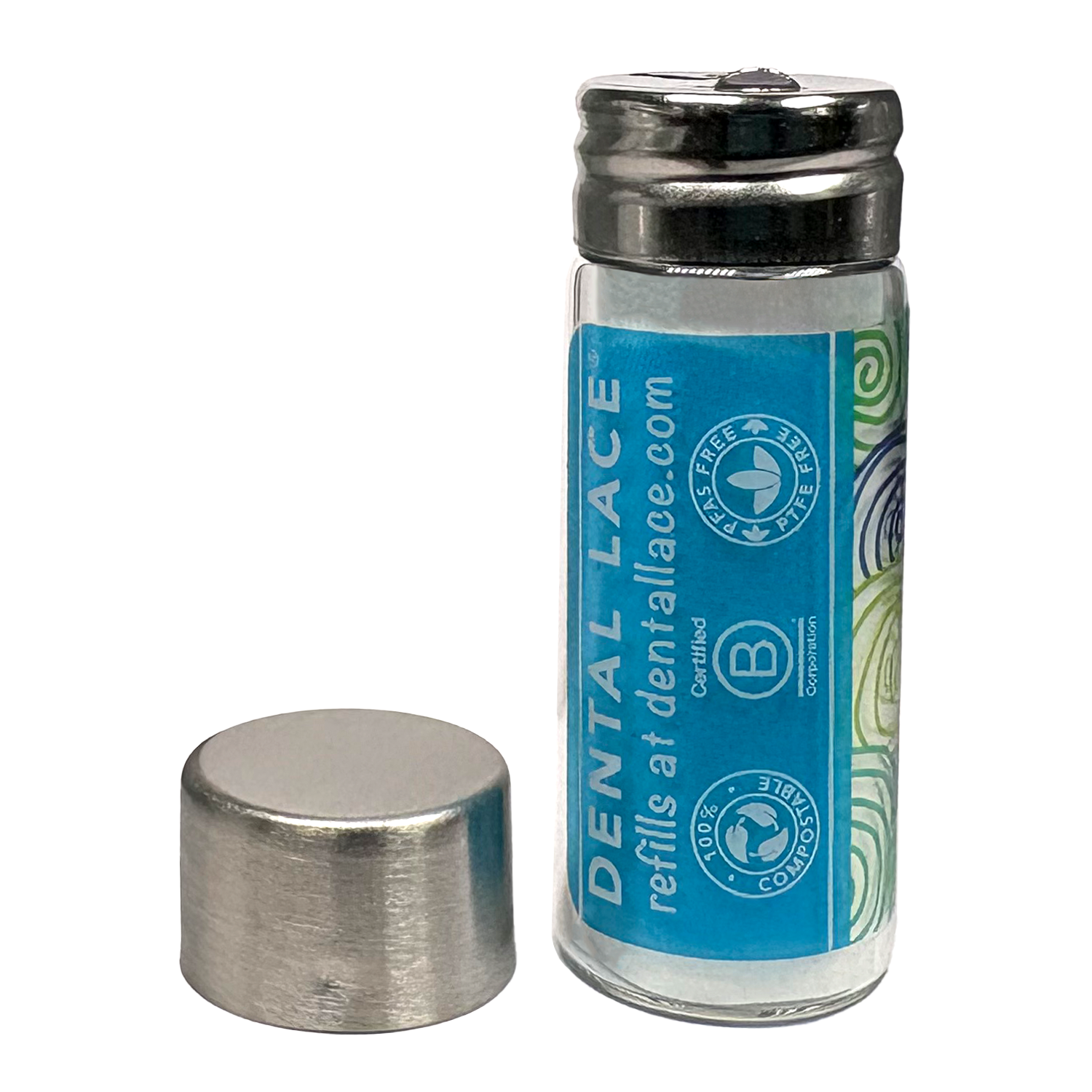 Cylindrical glass floss container with a metallic cap and blue ‘Dental Lace’ label on a white background.