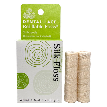 Dental lace refillable floss packaging with two silk floss spools on a white background