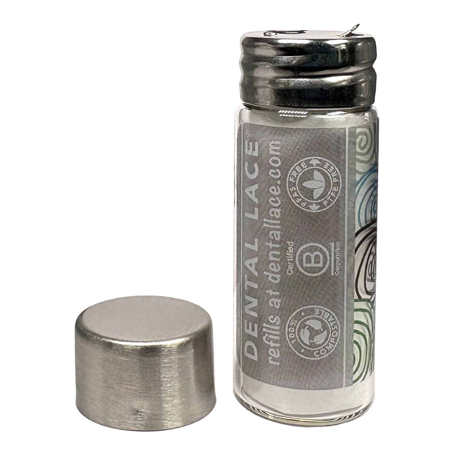 Cylindrical glass floss container with a metallic cap and gray ‘Dental Lace’ label on a white background.