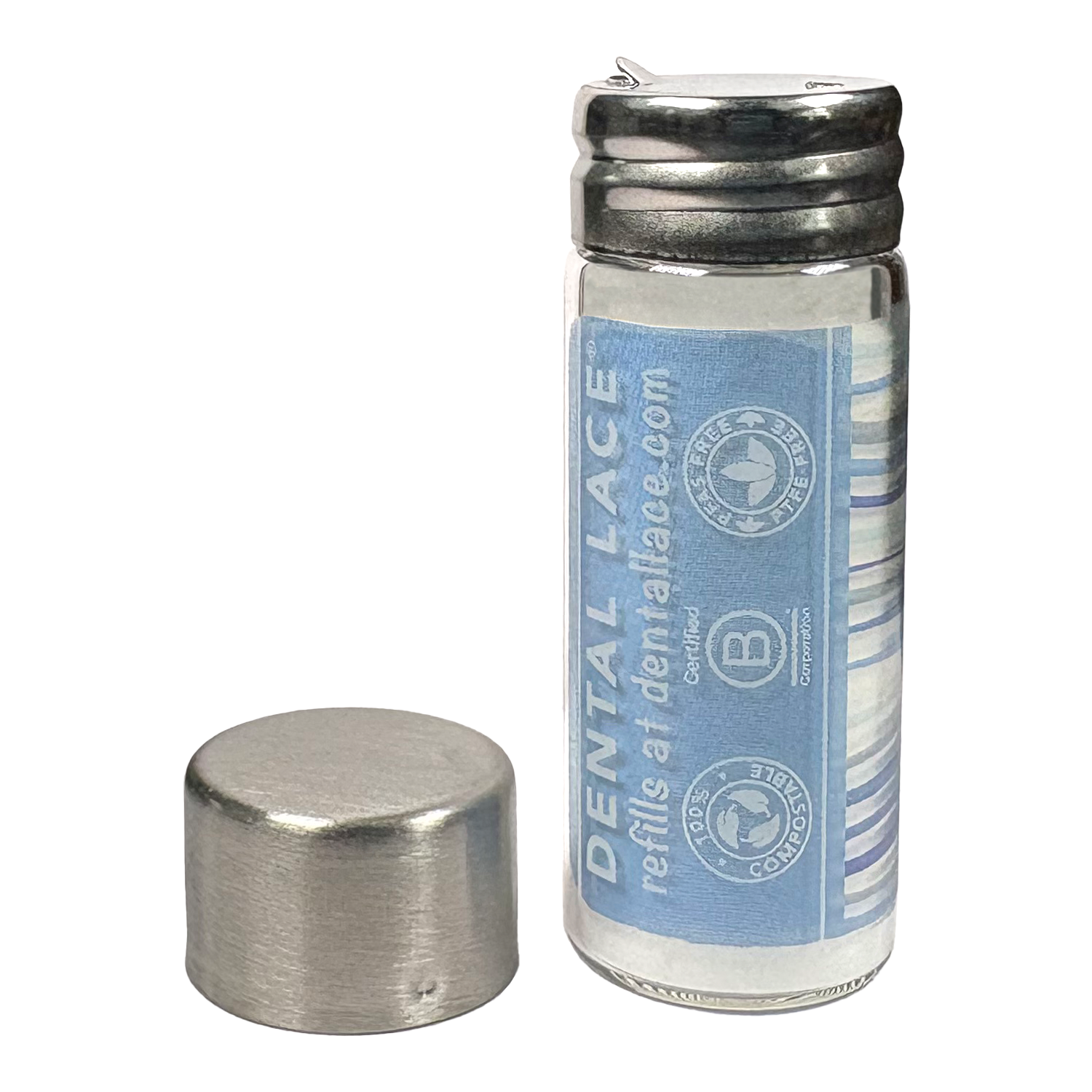 Cylindrical glass floss container with a metallic cap and waves ‘Dental Lace’ label on a white background.