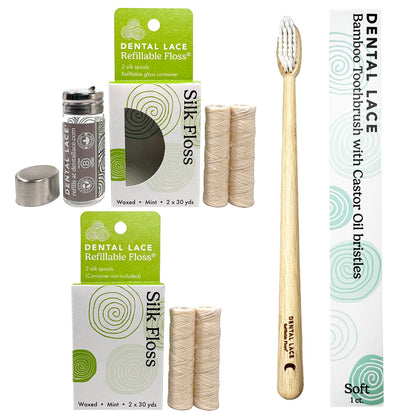 Dental care product set on a white background including a bamboo toothbrush with castor oil bristles, two boxes of Silk Floss, a spool of floss, a small glass container, and a separate cap.
