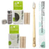 Dental care product set on a white background including a bamboo toothbrush with castor oil bristles, two boxes of Silk Floss, a spool of floss, a small glass container, and a separate cap.