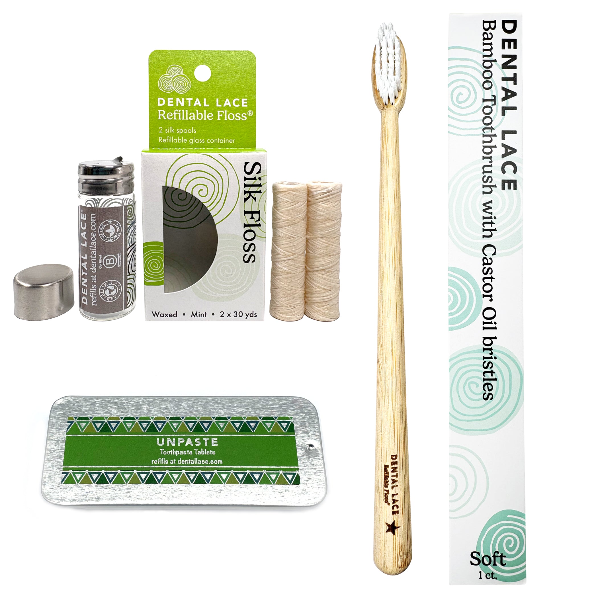 A bamboo toothbrush with a light wood handle and white bristles is shown alongside its white and green packaging box. The set also includes a glass jar of dental lace remover, two spools of silk floss, and a metal tray of Unpaste toothpaste on a plain white background.