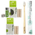 Dental care kit with a bamboo toothbrush, Silk Floss, and a refillable glass container. The toothbrush has a light natural wood handle and white bristles, shown next to its green and white packaging.