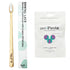 A bamboo  toothbrush with a light wood handle and white bristles, shown next to its white packaging sleeve and a white unpaste toothpaste pouch on a plain white background.